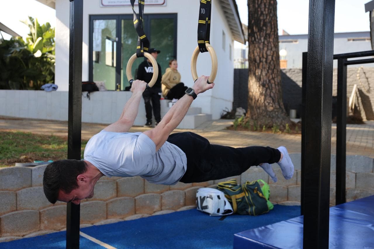 Athlete holding a straight-body front lever on gymnastic rings